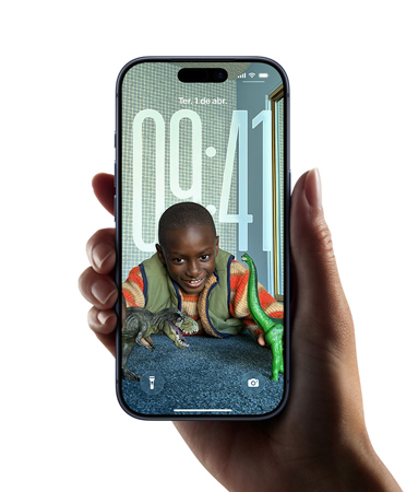 Uma mão segura um iPhone que mostra o novo design em Liquid Glass, que faz as horas se adaptarem dinamicamente à imagem da Tela Bloqueada