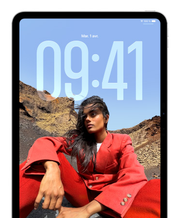 Écran verrouillé d’un iPad affichant l’heure en gros chiffres derrière la photo d’une personne assise