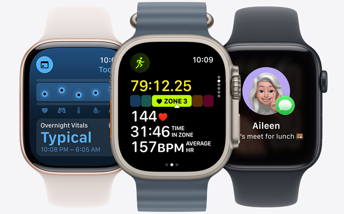 Three Apple Watch models, centre in Natural colour, face shows run in progress with heart rate stats, right in Jet Black, face with Genmoji, left in Rose Gold, face shows Vitals