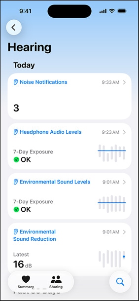 Na iPhonu je vidět probíhající sluchový test a vedle něj jsou umístěné AirPody Pro 3