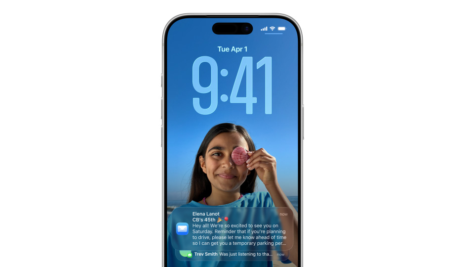 Zamknutá obrazovka iPhonu s fotkou a časem vyjádřeným číslicemi v Liquid Glass provedení, dole na displeji se objeví dvě oznámení