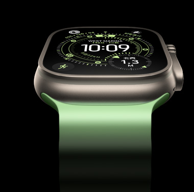ブラックを背景にしたナチュラルチタニウムのApple Watch Ultra 3のクローズアップ。時刻やそのほかのダイナミックな情報がディスプレイに表示されている