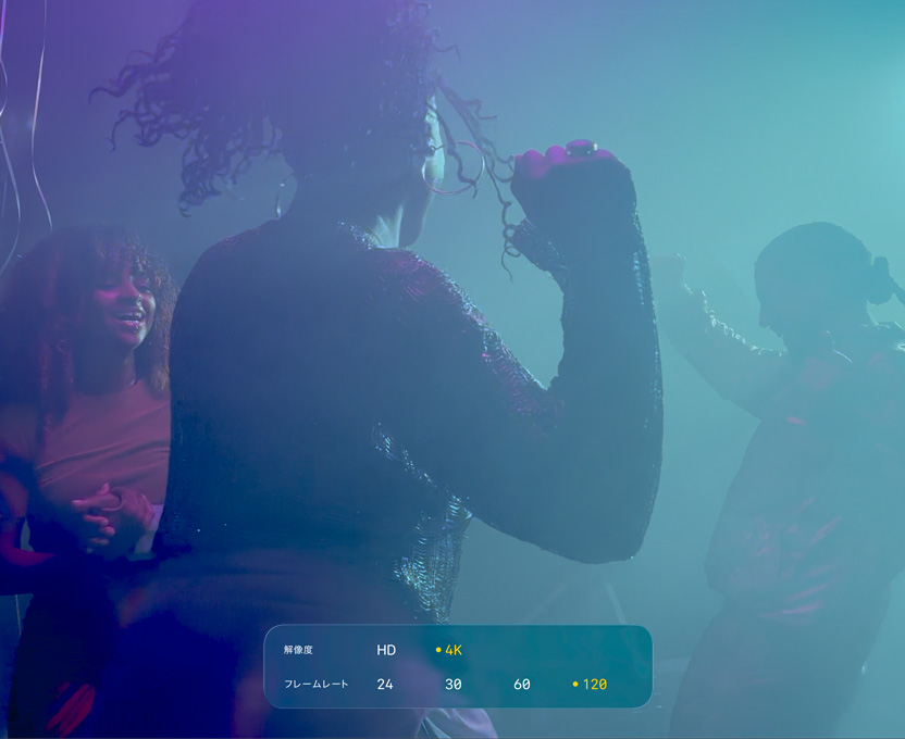 暗い場所で踊る3人の人物を撮影した画像。画面に、4K 120fpsのドルビービジョンの機能が表示されている