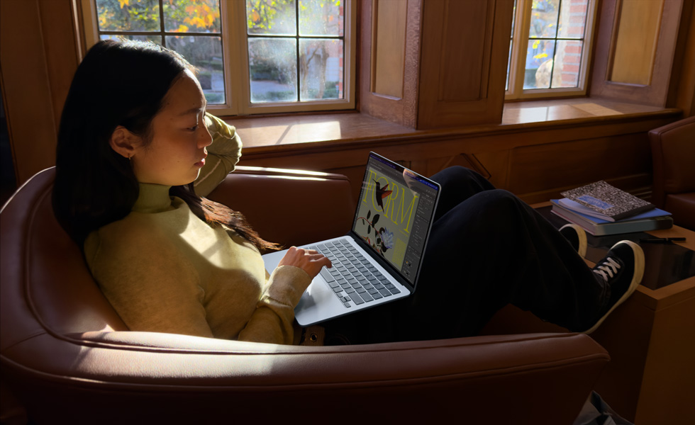 شخص يجلس على كرسي ويستخدم جهاز MacBook Air‏