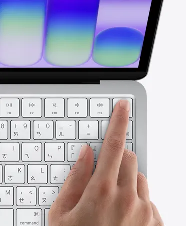 銀色 MacBook Neo，手指放在鍵盤右上角的 Touch ID 感測器上